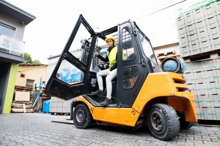 Female forklift truck driver outside a warehouse. forklift rental Toronto