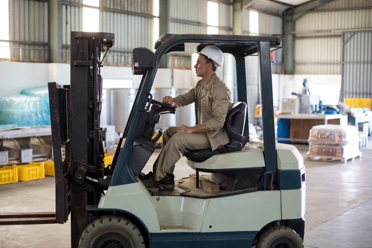 Featured image Worker driving forklift in oil factory